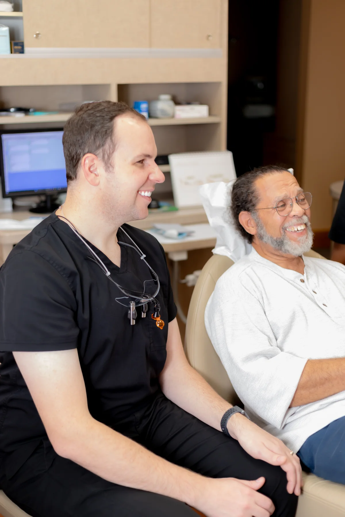 Dr. Smith smiling alongside a patient in a treatment room